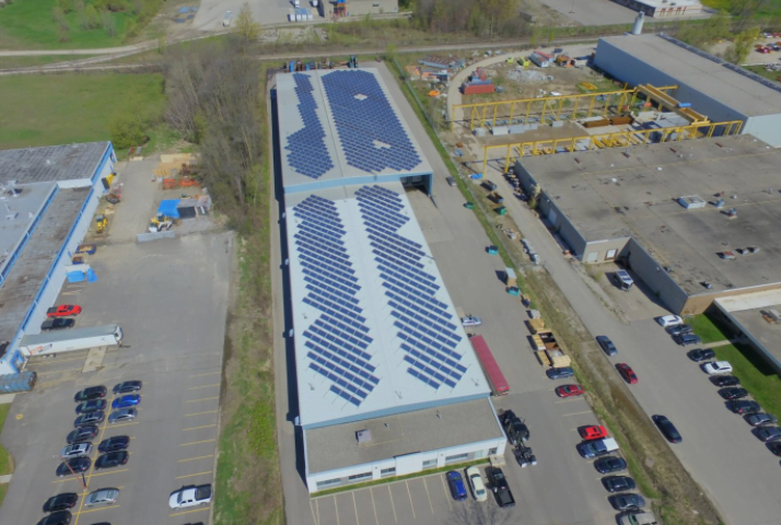 Aerial photo of solar panel array on the roof of a factory.